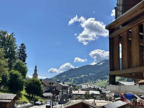 A town with a prominent church, a mountain in the background, and a mix of traditional and modern buildings.