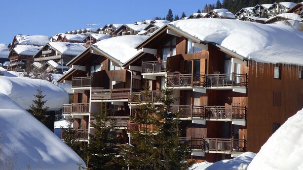 A multi-story wooden building with balconies, surrounded by snow-covered trees and other buildings. - Studio cabin Les Saisies 4 pers, near slopes (Les Saisies)