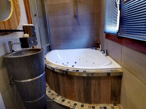 A modern bathroom with a freestanding bathtub, a wooden vanity, and a large mirror. - Cozy chalet with fireplace and parking, for 8 people (Les Gets)