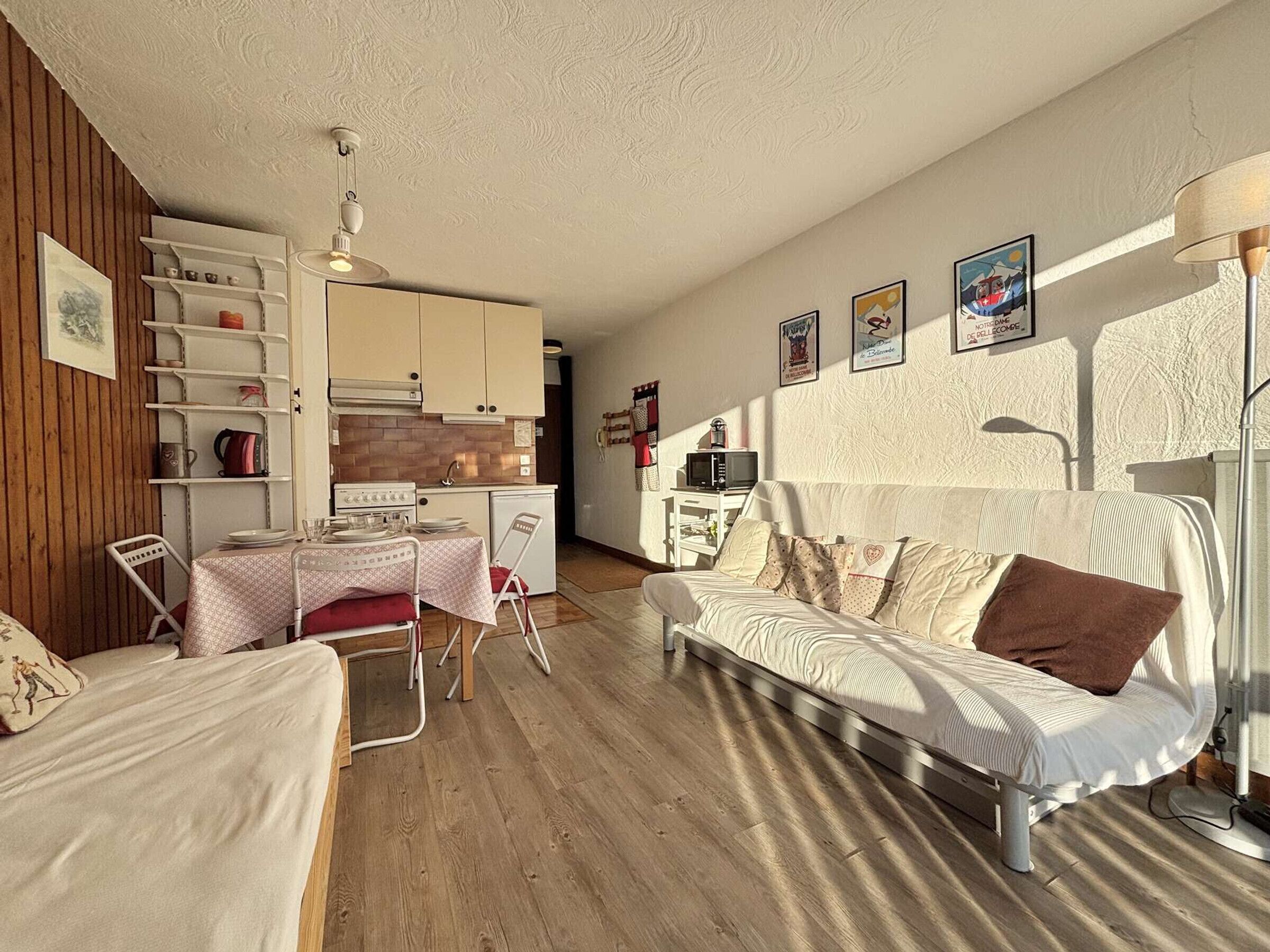 A compact living space with a kitchenette, a dining area, and a sofa.