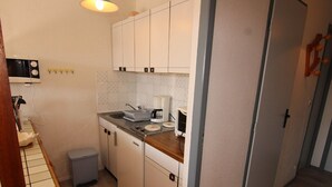 A compact kitchen with white cabinets, a small sink, a microwave, and a coffee maker. - 2-Room Apt - 5 people, Les Saisies, Pets allowed (Les Saisies)