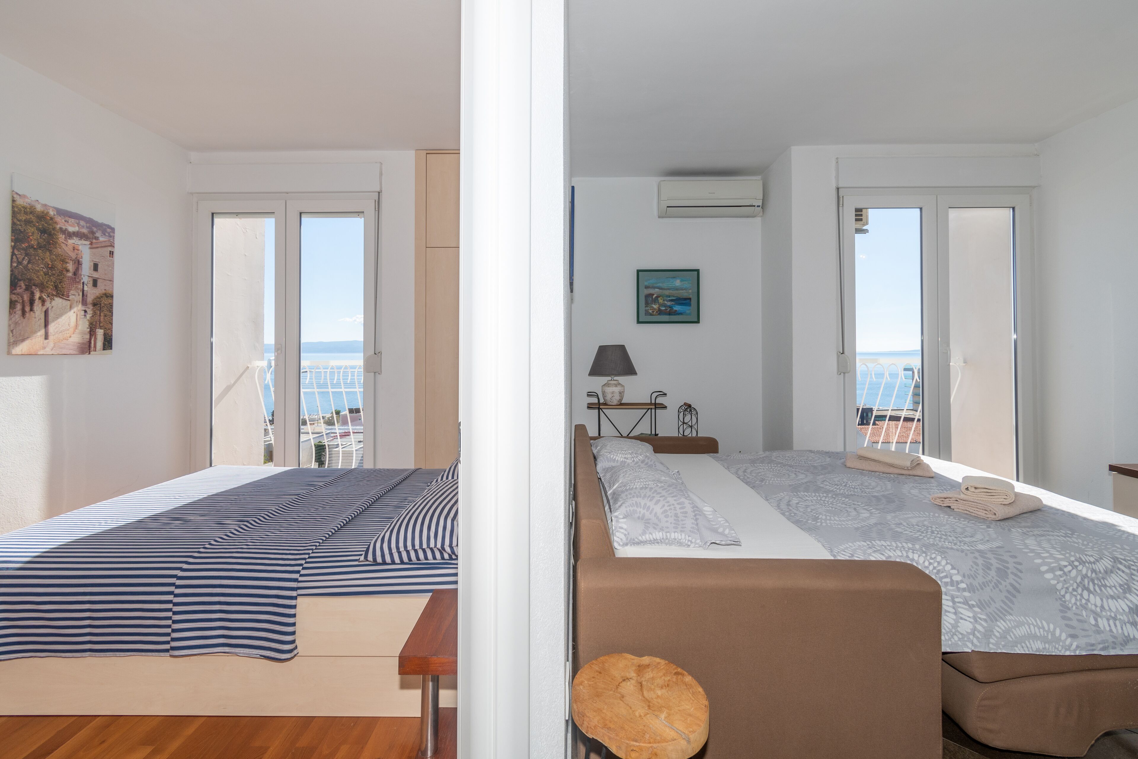Habitación de hotel con dos camas, un balcón y vista al mar.