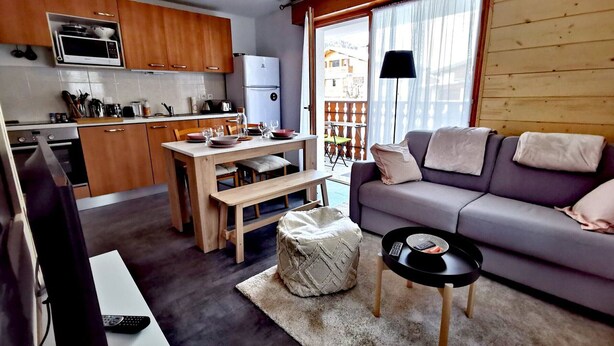 A compact living space with a kitchenette, a dining area, and a seating area with a sofa and a small table. - Renovated apartment for 4, near center, parking (Les Gets)