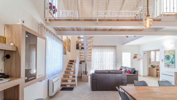 Eine mehrstöckige Wohnung mit Treppe, Essbereich und Wohnzimmer.