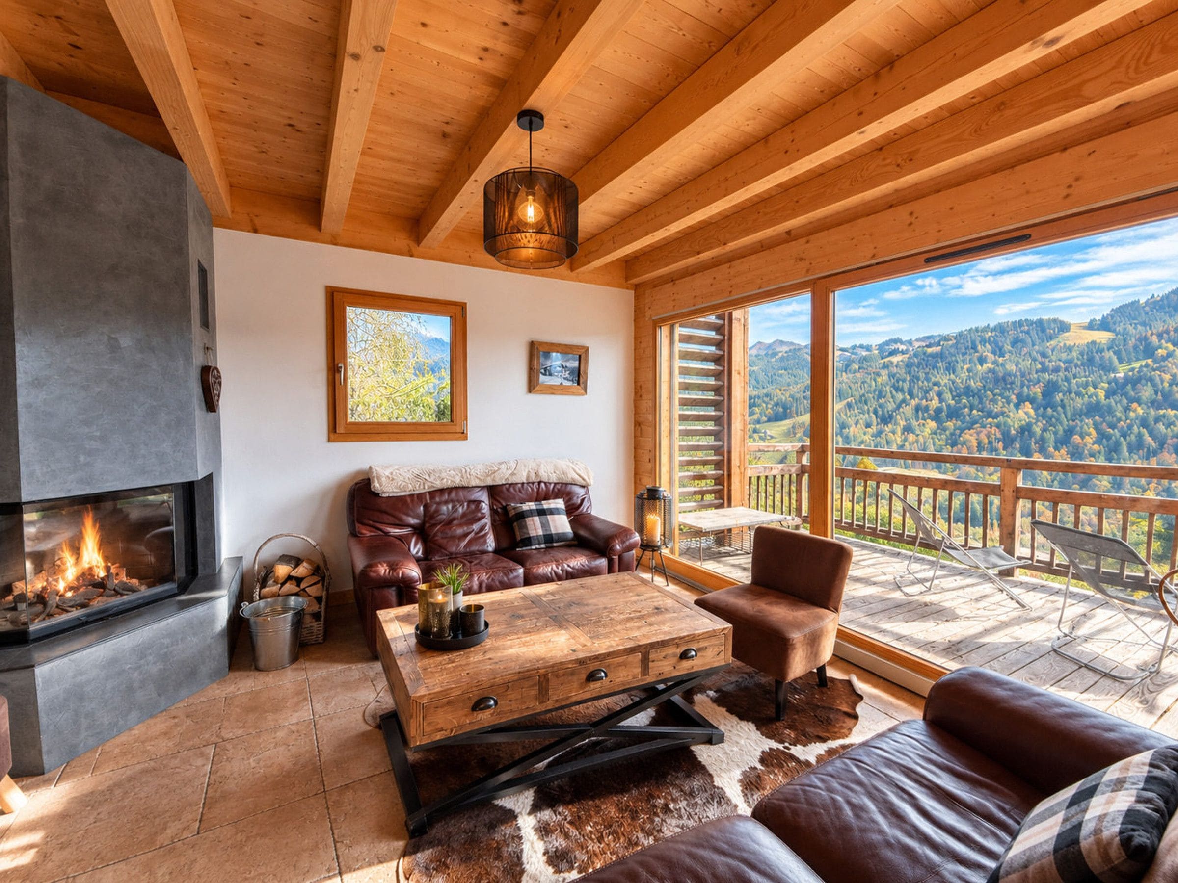 A cozy living room with a fireplace, leather sofa, wooden coffee table, and a scenic mountain view through large windows.