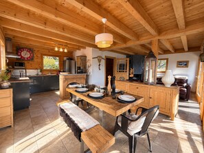 A wooden interior with a kitchen, dining area, and seating space.