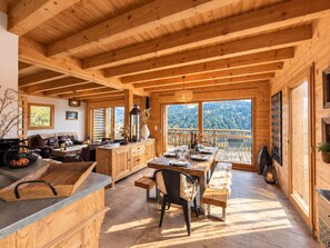 A wooden interior with a dining area, kitchen, and seating space. - Family chalet in Les Gets, quiet, parking, 8 people (Les Gets)