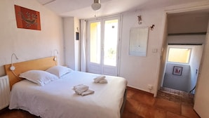 A bedroom with a bed, a radiator, a door, and a window. - Duplex with terrace & patio – old town Saint-Paul-Trois-Châteaux (Saint-Paul-Trois-Châteaux)