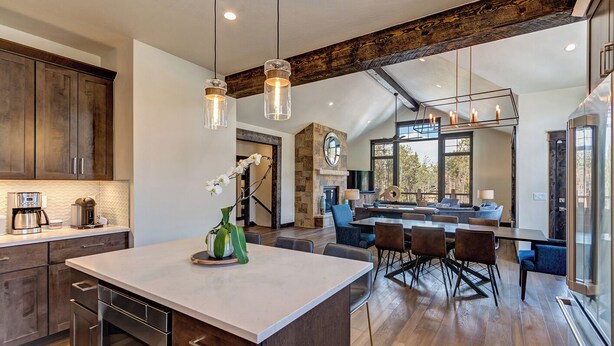 A spacious kitchen with a large island, wooden cabinets, and pendant lighting. - Stunning Luxury Home with Private Hot Tub! (Breckenridge)