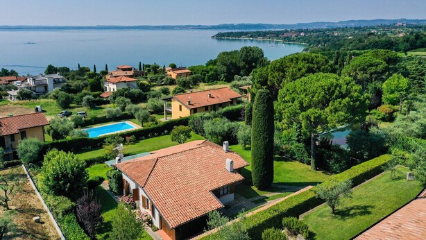 A residential area with houses, a swimming pool, and a view of a lake.