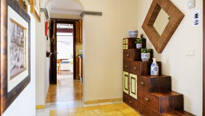 A hallway with a wooden staircase, a wall-mounted mirror, and a door leading to another room. - Casa La Goleta, Volcán y Mar (Playa Blanca)