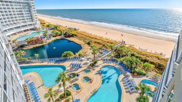 A hotel with a pool area, beach access, and ocean views. - Oceanfront family fun, multiple pools, great views + Free Attraction Tickets! (Myrtle Beach)