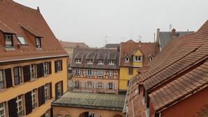 Une cour intérieure dotée d’une galerie couverte, entourée de bâtiments à l’architecture européenne traditionnelle, avec de nombreuses fenêtres et des balcons.