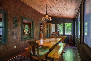 A wooden dining area with a bench, a table, and a chandelier. - Evergreen Lodge Old Forge (Old Forge)