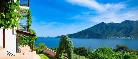 A building with a balcony overlooking a lake and mountains.