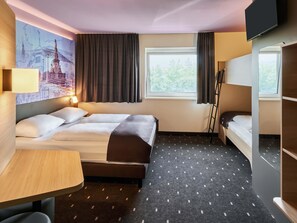 A hotel room with a bed, a desk, a chair, a TV, and a window with curtains. - B&B Hotel Heidelberg (Heidelberg)