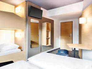 A modern hotel room with a bed, a desk, a chair, a TV, and built-in shelves. - B&B Hotel Kaiserslautern (Kaiserslautern)