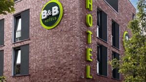 A hotel with a prominent B&B logo, a brick facade, and multiple windows. - B&B Hotel Kiel-Wissenschaftspark (Kiel)