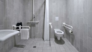 A modern bathroom with a bathtub, toilet, and shower area. - B&B HOTEL Köln-Ehrenfeld (Cologne)