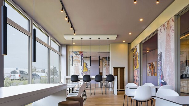 A modern dining area with high ceilings, large windows, and contemporary furniture. - B&B HOTEL Köln-Ehrenfeld (Cologne)