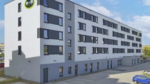 A modern B&B hotel with a white facade, multiple balconies, and a parking area with cars. - B&B HOTEL Köln-Ehrenfeld (Cologne)