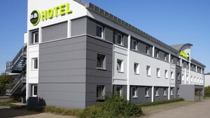 Ein modernes Hotelgebäude mit einem Schild, auf dem "B&B HOTEL" und "HOTEL" steht.