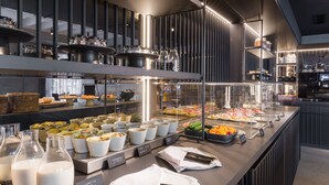 Zona de bufé con diversos alimentos y utensilios.