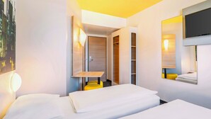 Habitación de hotel con dos camas, televisión, espejo y armario.