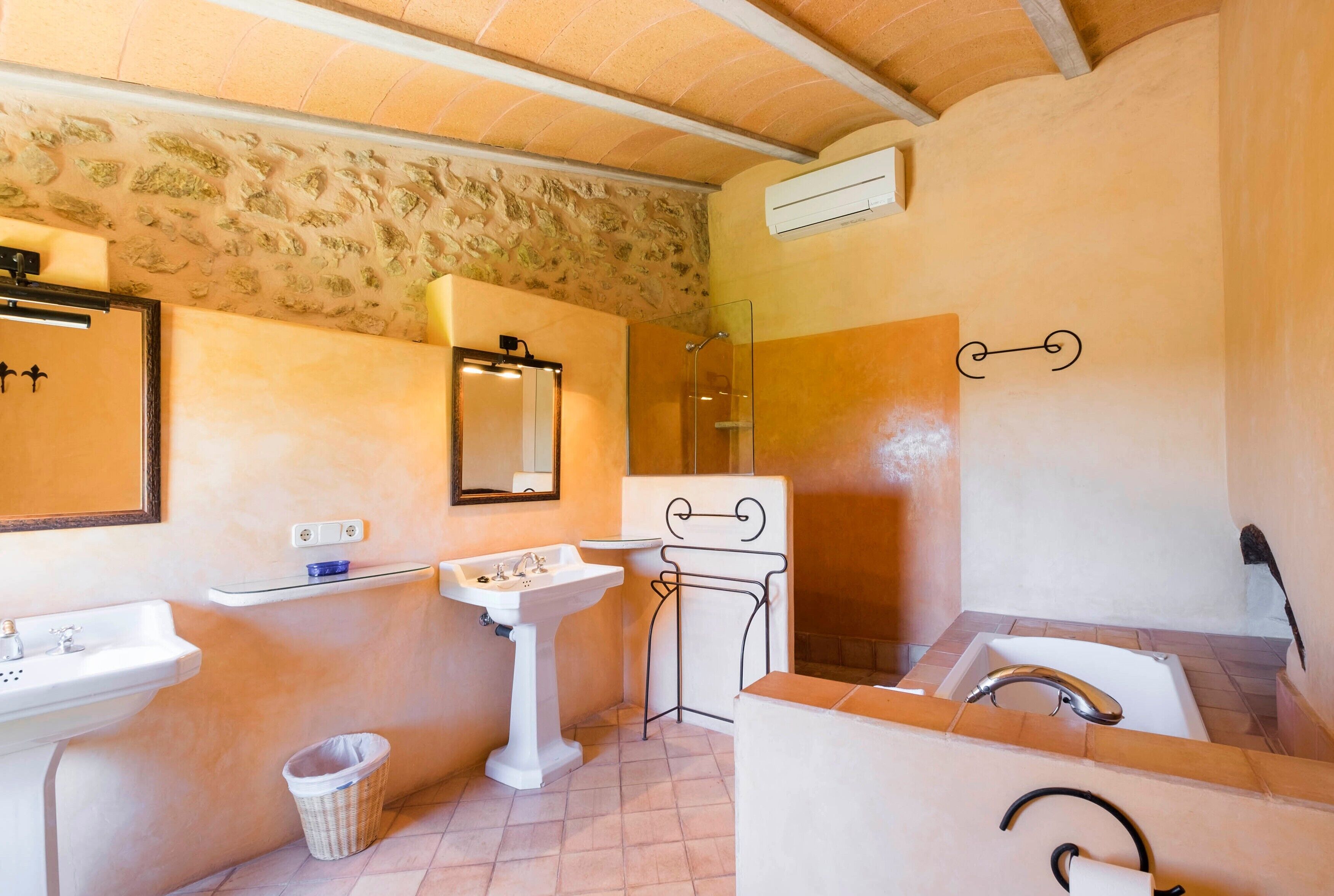 Une salle de bain équipée d’un lavabo, d’un meuble-lavabo, d’un miroir, d’une douche et d’une baignoire.