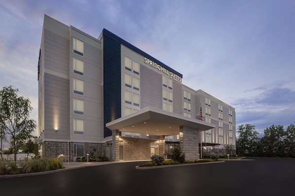 A modern hotel with a flat roof, large windows, and an American flag.