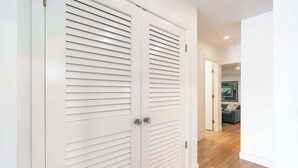 A hallway with a white door with horizontal slats and a visible handle.