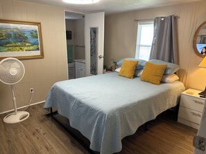 A bedroom with a bed, bedside table, lamp, and a fan. - Rainbow River Experience. (Dunnellon)