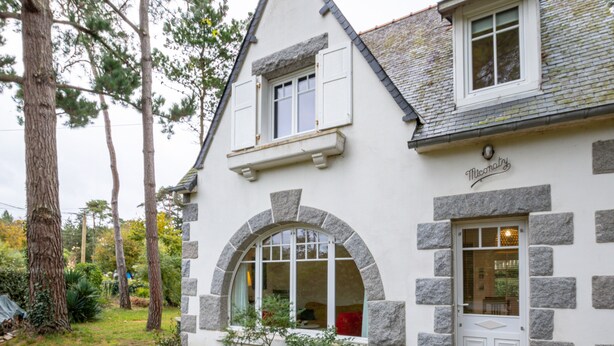 A stone building with a white door and arched windows.