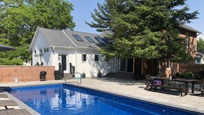 A swimming pool with a patio area, a barbecue grill, and a house in the background. - Vintage, restored home w/ pool, hot tub & courtyard-just blocks to town & beach (New Buffalo)