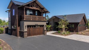 A two-story house with a wooden exterior, a balcony on the upper floor, and a garage.