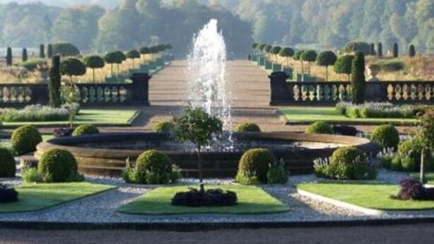 A formal garden with a central fountain, symmetrical pathways, and neatly trimmed hedges. - Townhouse @ 50 Birks Street Stoke (Stoke-on-Trent)