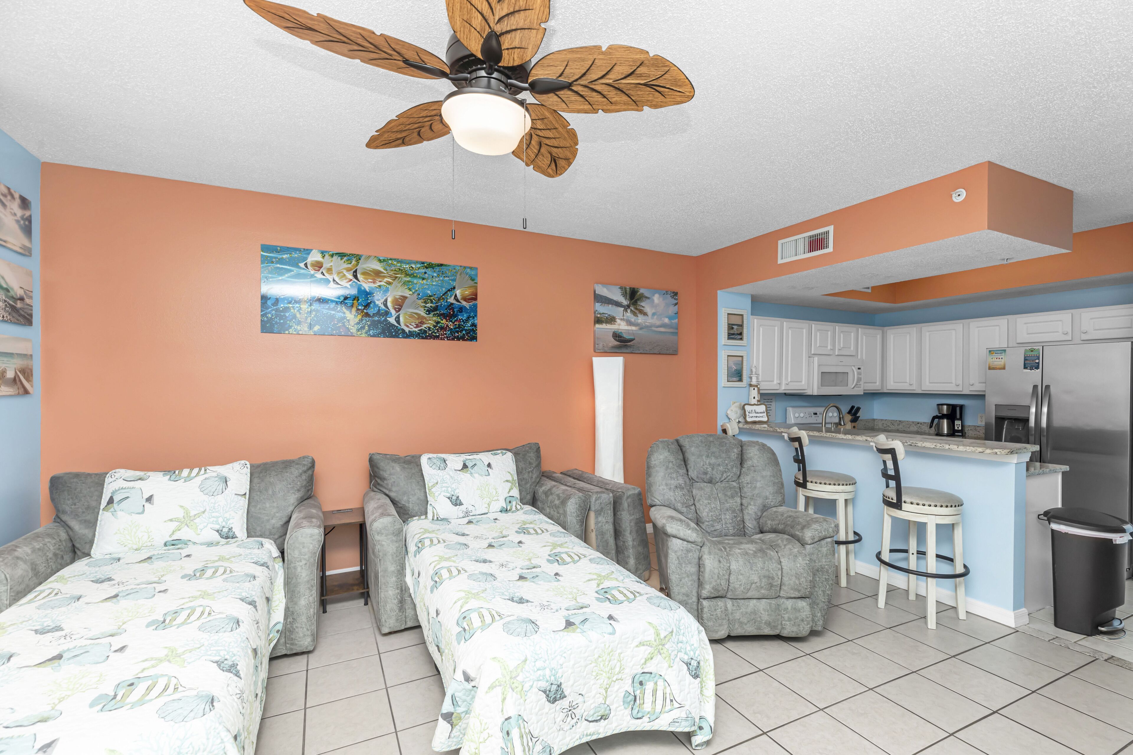 Huoneessa on kaksi erillistä sänkyä, kattotuuletin, pieni keittiönurkkaus ja ruokailutila, jossa on baarituoleja.