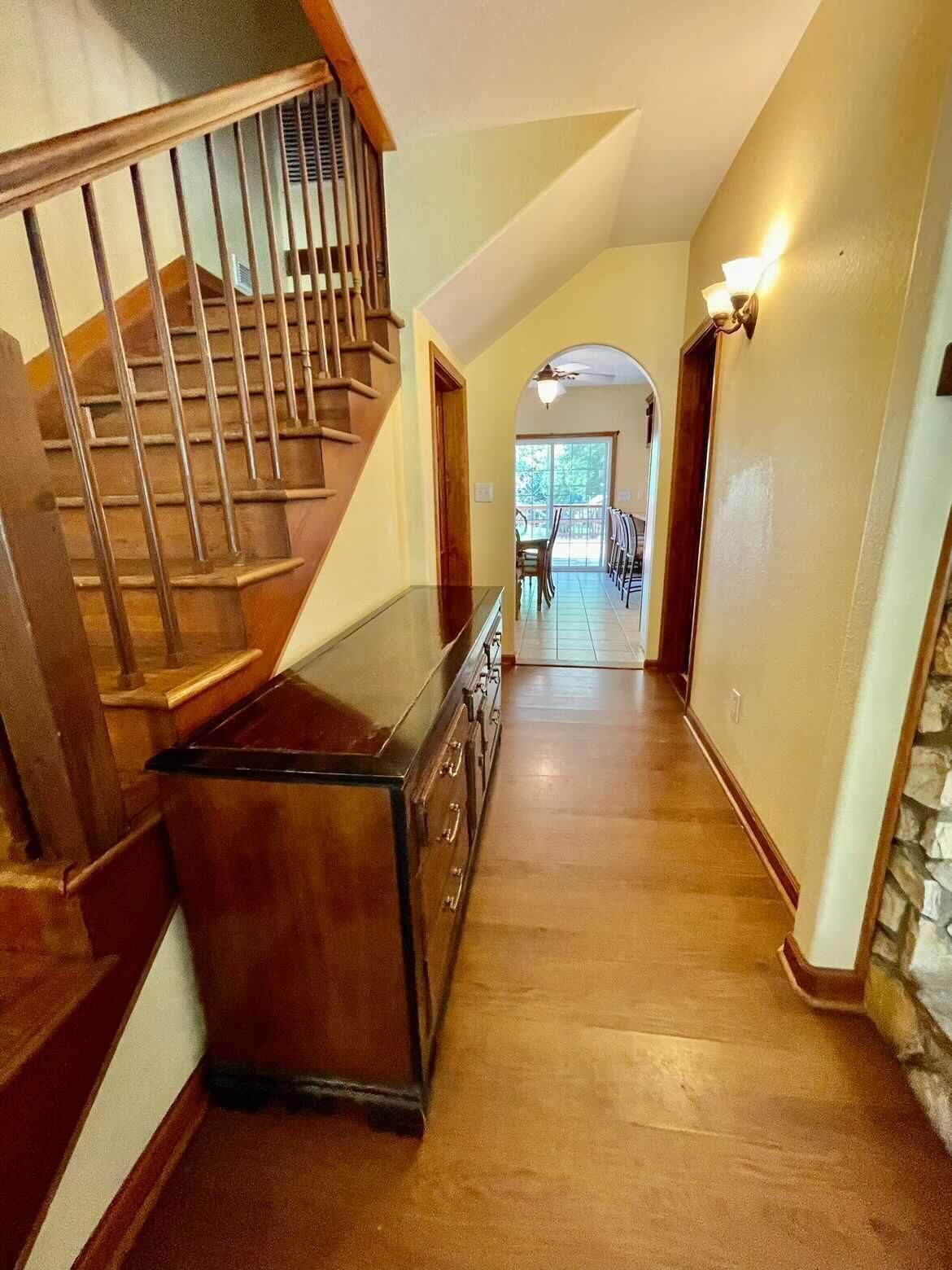 A wooden staircase leading to a dining area with a view of the outdoors.