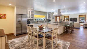 A spacious kitchen with a central island, white cabinetry, and a stainless steel refrigerator. - Incredible Sebastopol Estate Surrounded by Vineyards (Sebastopol)