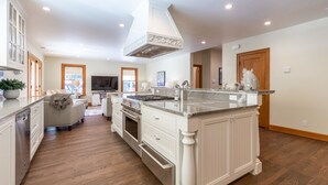 A spacious kitchen with a central island, white cabinetry, and a large window. - Incredible Sebastopol Estate Surrounded by Vineyards (Sebastopol)