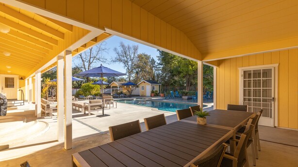 A covered outdoor area with a pool, lounge chairs, and a dining table. - Incredible Sebastopol Estate Surrounded by Vineyards (Sebastopol)