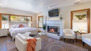 A bedroom with a fireplace, a bed, a sofa, and a chair. - Incredible Sebastopol Estate Surrounded by Vineyards (Sebastopol)