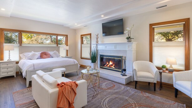 A bedroom with a fireplace, a bed, a sofa, and a chair. - Incredible Sebastopol Estate Surrounded by Vineyards (Sebastopol)