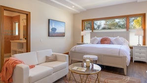 A bedroom with a bed, a bedside table, a nightstand, a window, a mirror, a sofa, and a round table with a candle. - Incredible Sebastopol Estate Surrounded by Vineyards (Sebastopol)