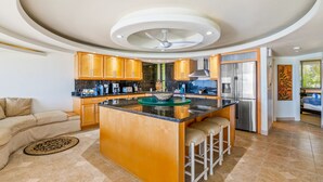 Een moderne keuken met een centraal eiland, houten kastjes en roestvrijstalen apparatuur.