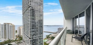 A high-rise building with a balcony featuring a pool, lounge chairs, and a view of the sea. - ICON W BRICKELL PANORAMIC OCEAN VIEW 1BR/1BA/DEN #3011 (Miami)
