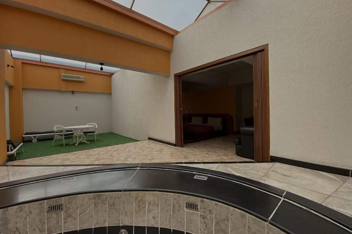 Een hotelkamer met dakraam, een klein balkon met een tafel en stoelen, en een bed.
