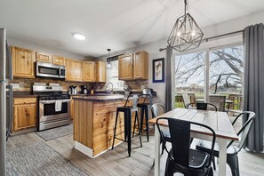 Enjoy cooking and dining in this well-lit kitchen with a central island, stainless steel appliances, and wooden cabinetry.