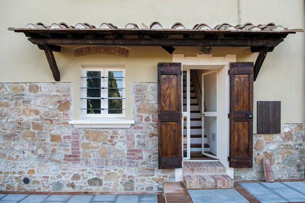 Un bâtiment en pierre avec une porte en bois et une fenêtre.
