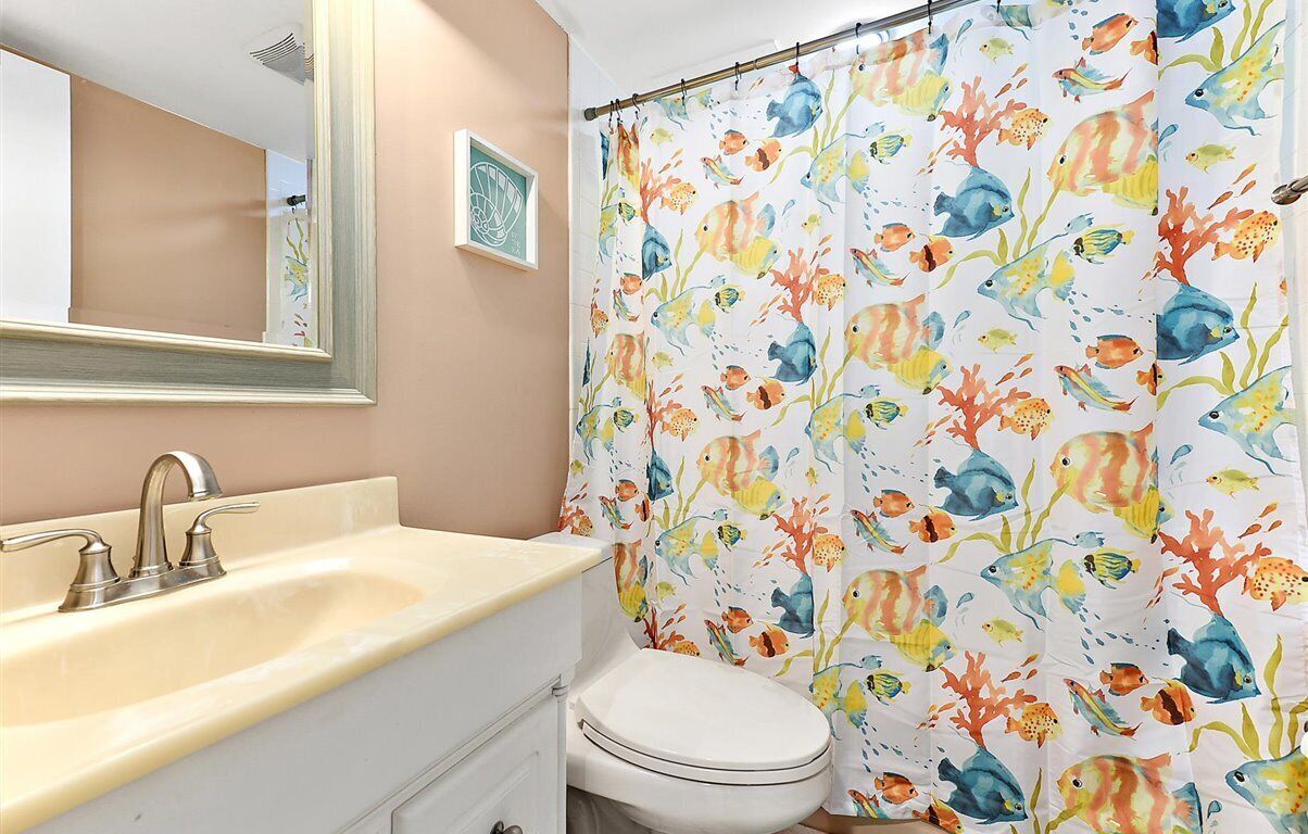 A bathroom with a sink, mirror, and toilet.